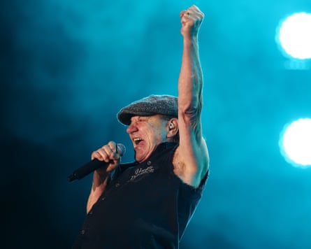 Brian Johnson sings with one fist raise