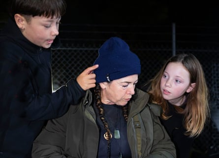 A tired-looking Walker sits between her children