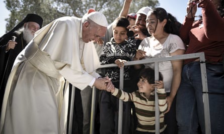 A boy shakes the hand of Pope Francis