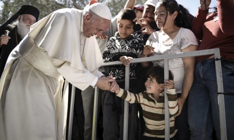 Pope Francis shakes hands with a boy in the Moria refugee camp in Lesbos.