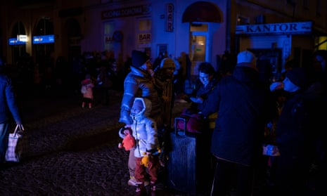 Ukrainian refugees wait to board buses outside the train station in Przemyśl, near the Polish-Ukrainian border.