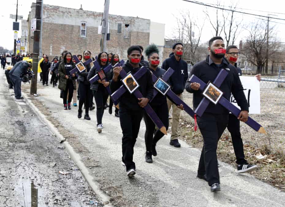 High school senior D’Angelo McDade, front right, leads a march in Chicago to protest gun violence.