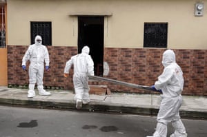 Police officers and medical personnel collect a body from a house