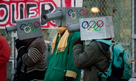 Protesters with fake surveillance cameras on their shoulders with Olympic rings