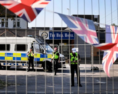Oficerët e policisë jashtë hotelit Bell, të parë përmes gardhit në të cilin janë ngjitur flamuj sindikalë.