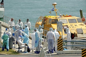 Healthcare workers attend to a crew member showing Covid-19 symptoms after arriving from a cruise ship off the coast of Miami.