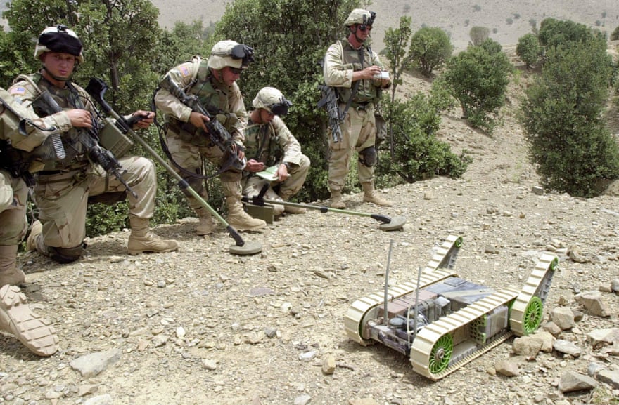 US soldiers alongside a landmine detection robot in Afghanistan.