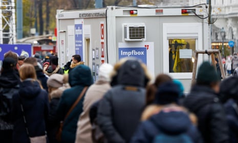 People wait in front of a vaccination point in Vienna, Austria.