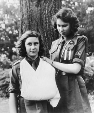 1943: Princess Elizabeth, right, and Princess Margaret in Guides uniforms, practise bandaging skills. They belong to the 1st Buckingham Palace Company of Guides, which they joined in 1937. Elizabeth wears the badge of the swallow patrol and two white stripes, which indicate she is patrol leader
