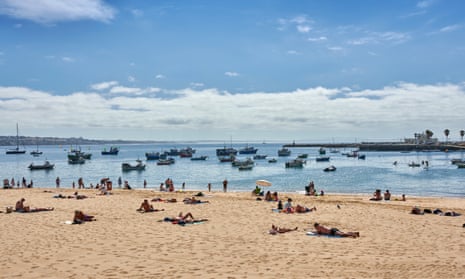 Holidaymakers on the beach at Cascais in Portugal.