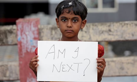 young girl holds a placard during a protest against the rape of an eight-year-old girl in Kathua, near Jammu, India