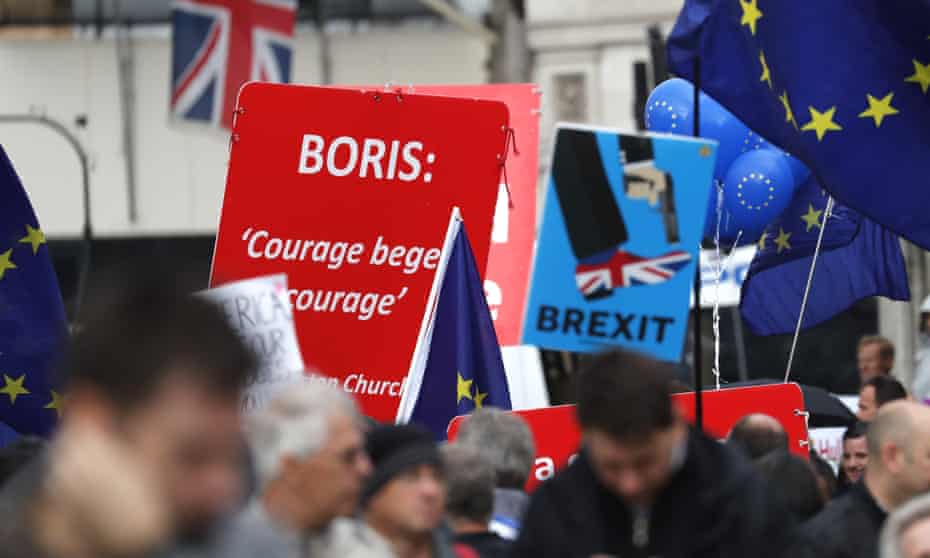 Pro and anti-Brexit supporters hold signs and flags while demonstrating outside the Parliament in London, Wednesday, Sept. 25, 2019.