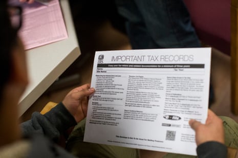 A person holds an IRS document titled 'Important Tax Records' while seated indoors.