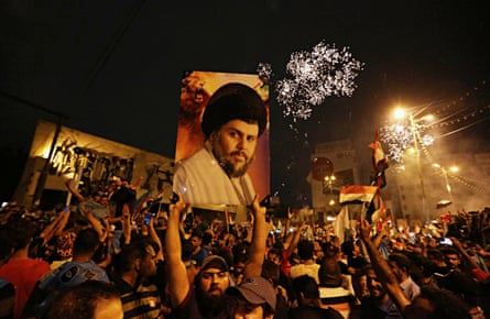 Followers of Shia cleric Muqtada al-Sadr, seen in the poster, celebrate in Tahrir Square, Baghdad, Iraq, early on 14 May 2018.