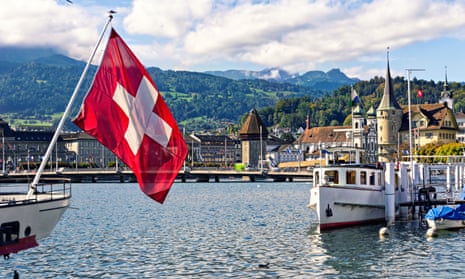 Swiss flag against background of historical centre of Lucerne and Swiss Alps. Switzerland, Europe.