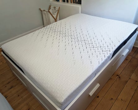 The Nectar Classic mattress on a white bedframe in a wooden-floored room