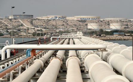 Wide white pipes cross the water at the oil terminal with storage facilities on the island.