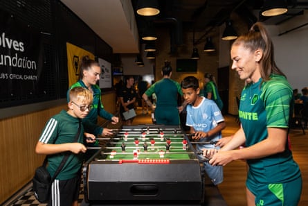The Wolves players Mel Lawley (left) and Chloe Williams play table football with attendees during a summer youth club organised by the Wolves Foundation at Molineux