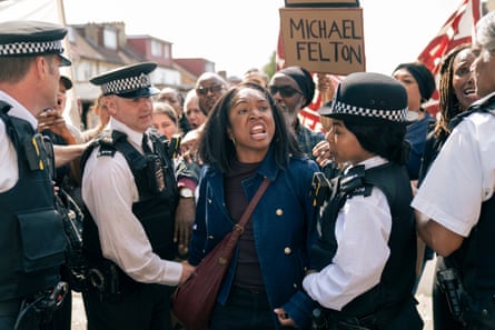 A woman is restrained by four police offices at a demonstration
