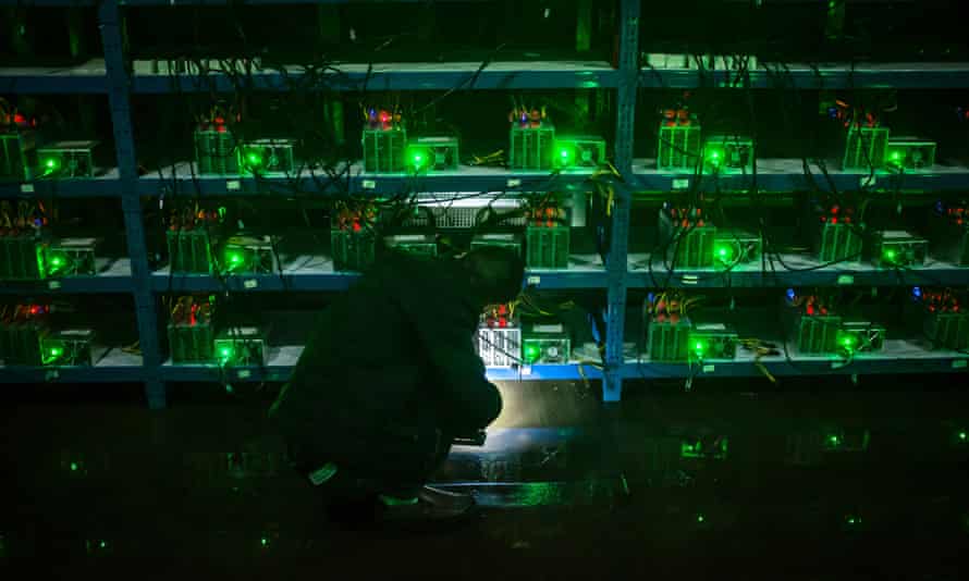 Bitcoin miner Huang inspects a malfunctioning mining machine during his night shift at the Bitcoin mine in Sichuan Province, China