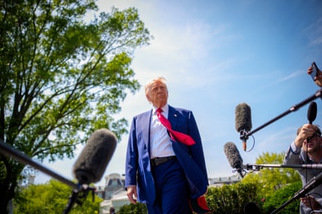 A man who is donald trump stands in front of microphones outside