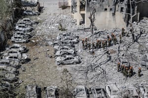 Search and rescue workers in Beersheba, Israel, go through rubble including burnt out cars covered with ashes at the site of a partial collapse of a seven-story building, after a ballistic missile was fired from Iran.