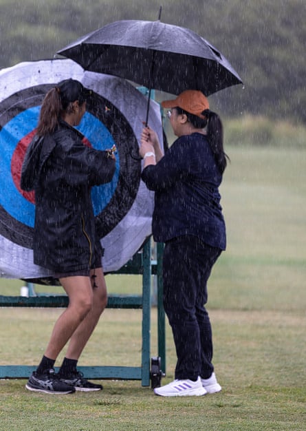 Virasha helps Jennifer retrieve an arrow from the target in pouring rain