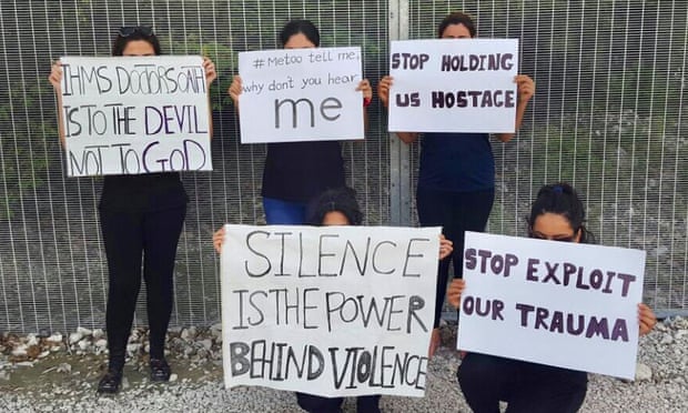 Women on Nauru holding up signs in front of their faces