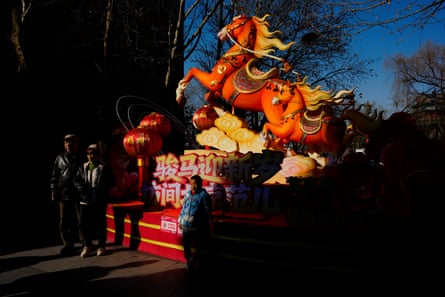 Tourists pose for a group photo in front of a horse during lunar new year