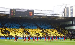 Watford fans hold cards in the colors of Ukraine's flag to signify peace and sympathy with Ukraine.