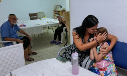 A woman comforts her child as they take cover in a shelter in Ashkelon on Tuesday