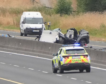 Police attending the scene of the crash with the wreckage of one of the cars still on the motorway