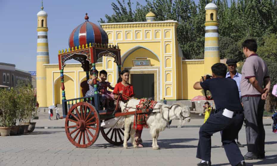 Children ride in a goat-drawn carriage in Kashgar, Xinjiang. Poets and researchers have warned that Uighur poetry is on the verge of extinction as Beijing detains and silences poets. 