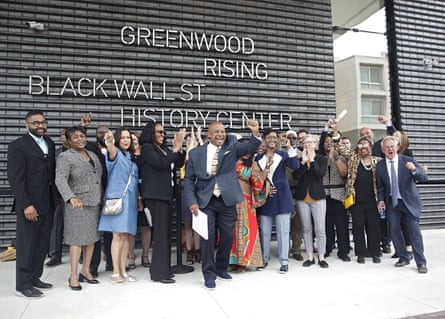Members of the 1921 Tulsa Race Massacre Centennial Commission, with Sen. Kevin Matthews in front, cheer while getting their picture taken in front of the Greenwood Rising Black Wall Street History Center