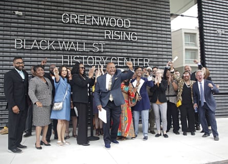 Members of the 1921 Tulsa Race Massacre Centennial Commission cheer while getting their picture taken in front of the Greenwood Rising Black Wall Street History Center on 2 June.