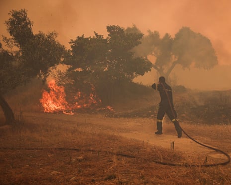 A fireman runs to extinguish a fire in an olive grove in the settlement of Zachouli, Greece, August 2, 2026