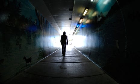 Woman walking through a dark tunnel