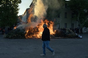 A man walks by a fire in the street