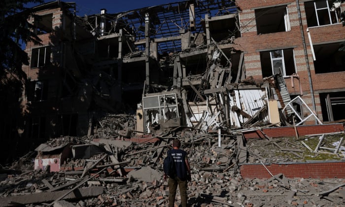 A worker from the war crimes prosecutor’s office takes in the damage from overnight shelling that landed on a building of Kharkiv’s Housing and Communal College as Russia’s attack on Ukraine continues in Kharkiv, Ukraine, June 21, 2022.