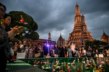 People gather around an artificial pond at Wat Arun Buddhist temple.