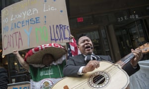 A demonstrator dances and sings along the Mariachi Tapatio de Alvaro Paulino band as they perform during a demonstration across the street from the building that once housed the office space of Aaron Schlossberg Friday in New York.