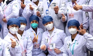 Medical workers pose for photos after a Fangcang makeshift hospital was officially closed at Wuhan International Convention & Exhibition Center on March 9, 2020 in Wuhan, Hubei Province of China.