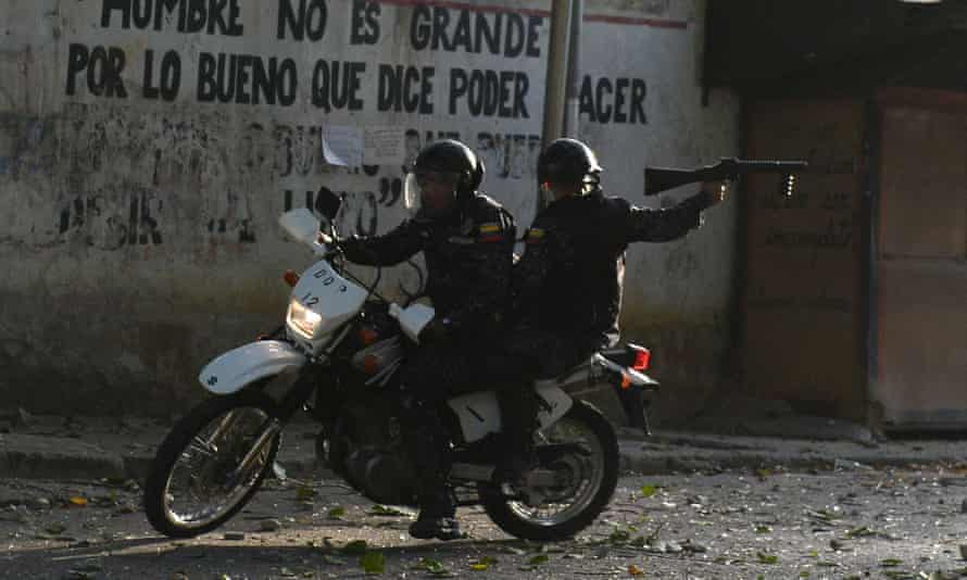 A riot policeman on a motorcycle points his gun during clashes with anti-government demonstrators in the neighborhood of Los Mecedores, in Caracas, on Wednesday.