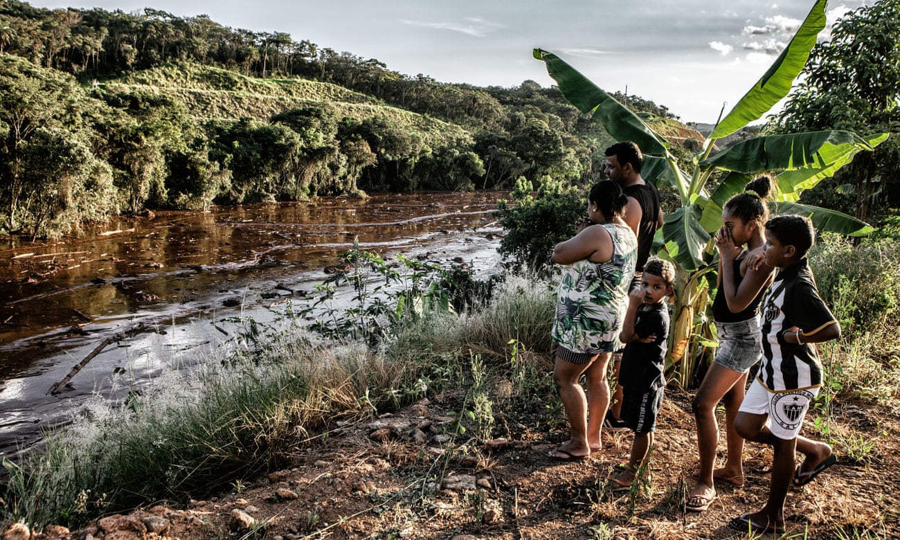 Aline Tiberio, 36, Claudio de Almeida, 39, and their children Kaio, 5, Isabelly, 10 and Kaua, 8, look at the waste from the mine leak. 