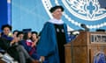man in blue academic gown and cap on a stage