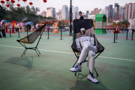 A robot sitting on a chair in Victoria Park on
