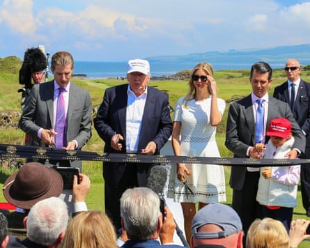 Donald Trump cuts a ribbon as his family stand alongside