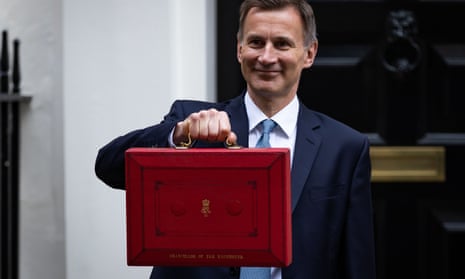 Jeremy Hunt displays the red budget briefcase in Downing Street, London.