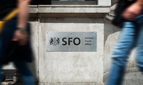 Pedestrians walk past the sign outside the headquarters of the Serious Fraud Office in London