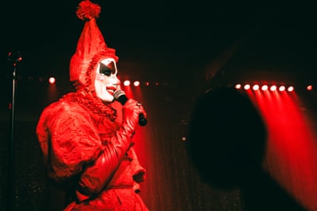 a person dressed in red as a clown performing